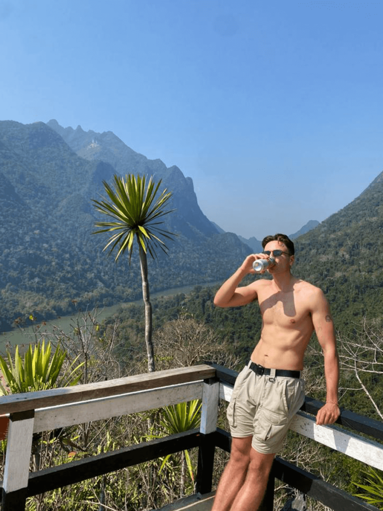 Drinking a beer in Laos at the top of the Phanoi Viewpoint Hike. A popular thing to do in Muang Ngoy, Laos.